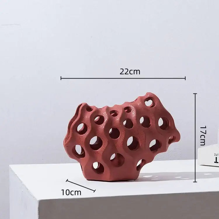 A terracotta-colored coral geometric resin sculpture with porous honeycomb design for modern living room decor