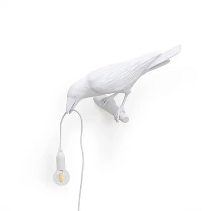 Modern white ceramic wall lamp with exposed bulb hanging from beak decorbites designer bird wall decor