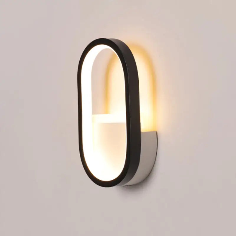 Modern black-framed oval wall lamp with warm white led light ideal for bedroom lighting and modern decor