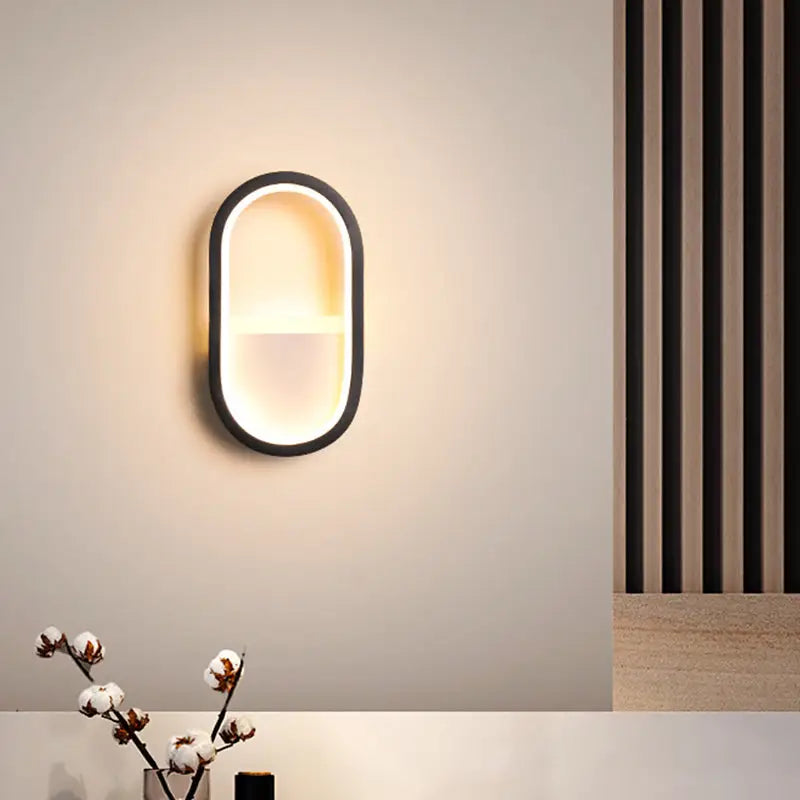 Modern white and black ellipse led wall lamp with sleek black frame and warm white diffused lighting for bedrooms