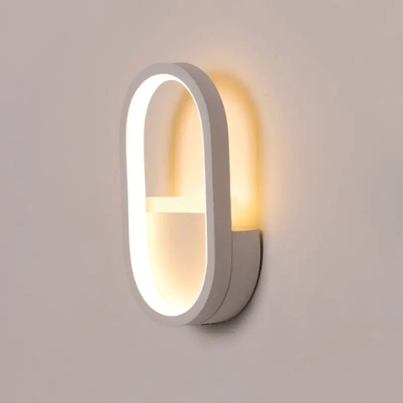 Modern white oval wall lamp with black ellipse frame and warm white led lighting for bedroom use