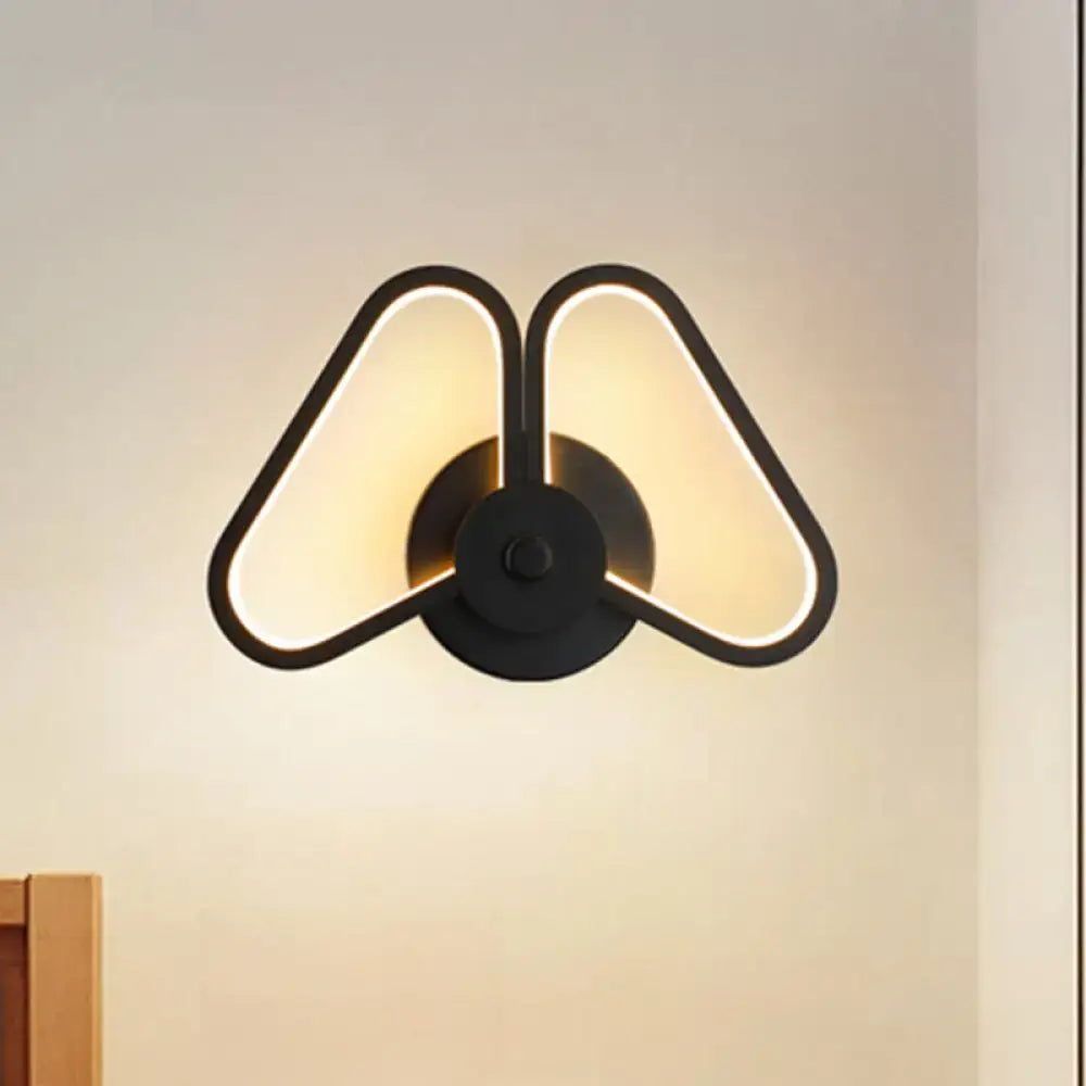 Modern white and black led triangle wall sconce with black minimalist design and warm illuminated triangular arms for living room lighting
