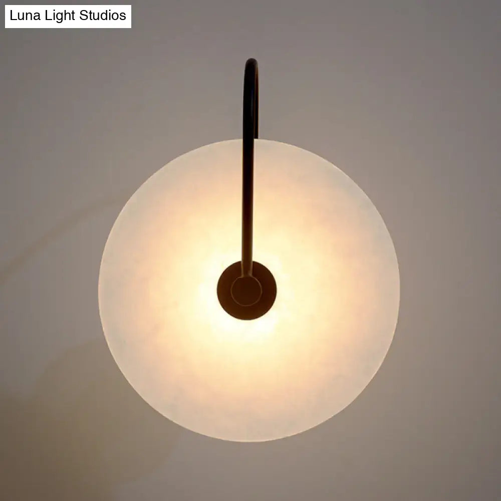 Modern white and black led wall sconce with a frosted disc shade and sleek black metal arm fixture width ideal for bedrooms