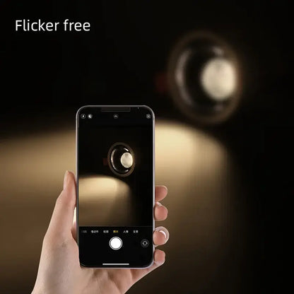 A sleek black smartphone held in hand displays a light source photo of decorbites 12w modern white and black recessed downlight spotlights