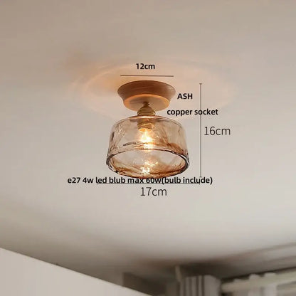 A warm-toned amber glass pendant light with copper socket and wooden base for modern ceramic led ceiling lamp use