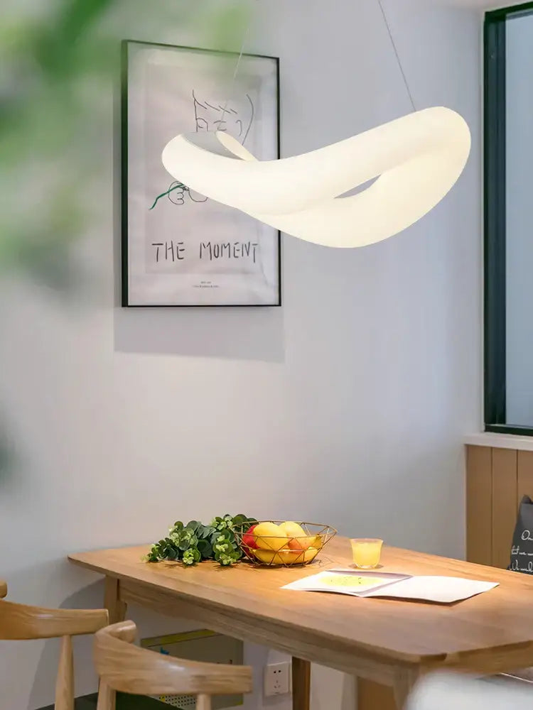 A modern white bubble led chandelier with smooth flowing design hangs above wooden dining table decorbites bubble led