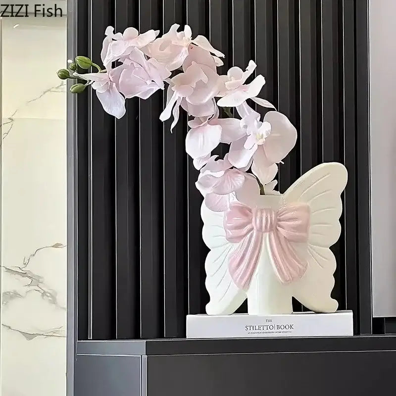 A modern white butterfly ceramic vase with pink bow holding light pink orchid flowers for bedroom decorbites butterfly ceramic