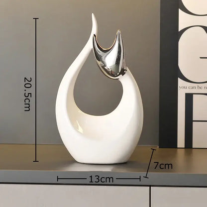 A sleek white ceramic kitten statue with glossy finish and silver metallic accent for modern living room decor