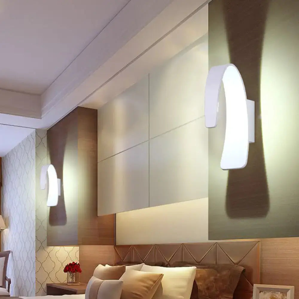 Modern white curved wall light with direct wired electric setup emitting warm white light for living room use