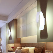 Modern white curved wall light with direct wired electric setup emitting warm white light for living room use