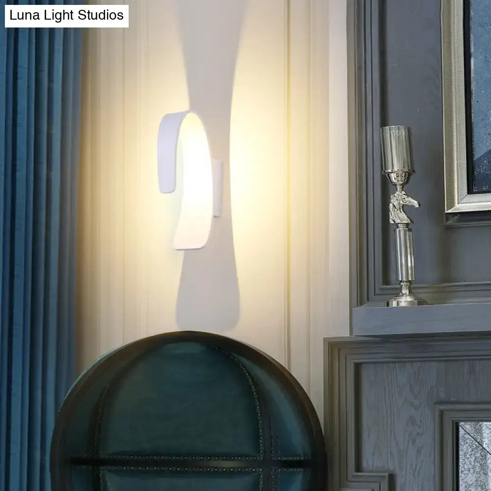 Modern white curved wall light with sleek design and direct wired electric installation emitting warm white light for living room