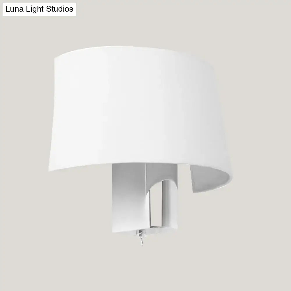Modern white fabric sconce with a white cylindrical lampshade and sleek metallic base for a bedroom wall lighting idea