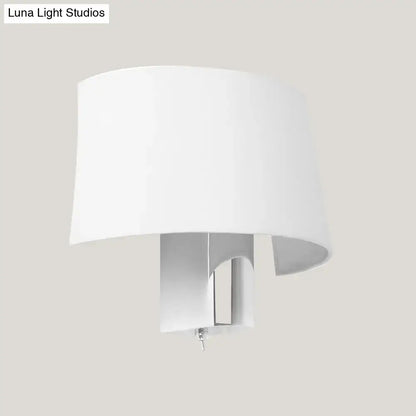Modern white fabric sconce with a white cylindrical lampshade and sleek metallic base for a bedroom wall lighting idea