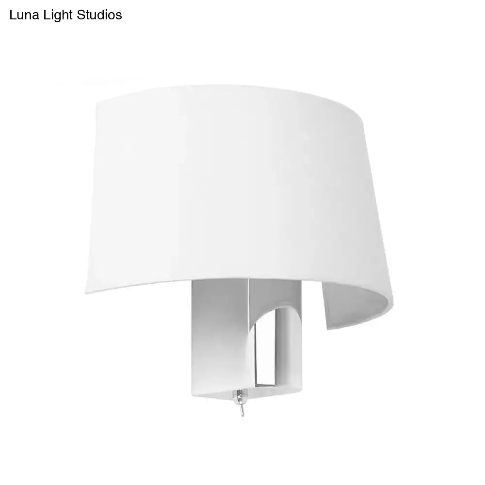 Modern white fabric sconce with a drum-shaped lampshade and minimalist metal base wall lighting idea for bedroom