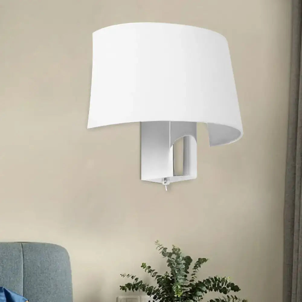 Modern white fabric sconce with a curved shade providing a sleek wall lighting idea for bedroom walls