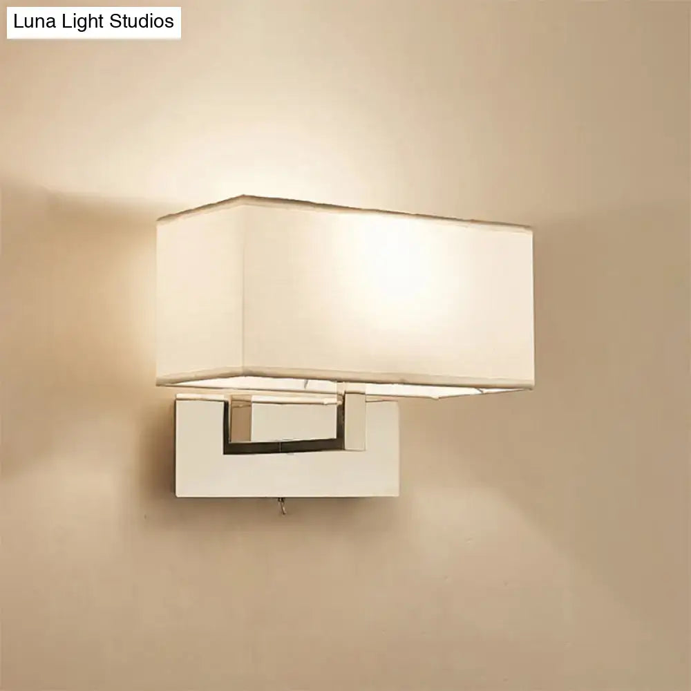 Modern white wall sconce with a white fabric shade and sleek chrome-finished metal base for bedroom wall light