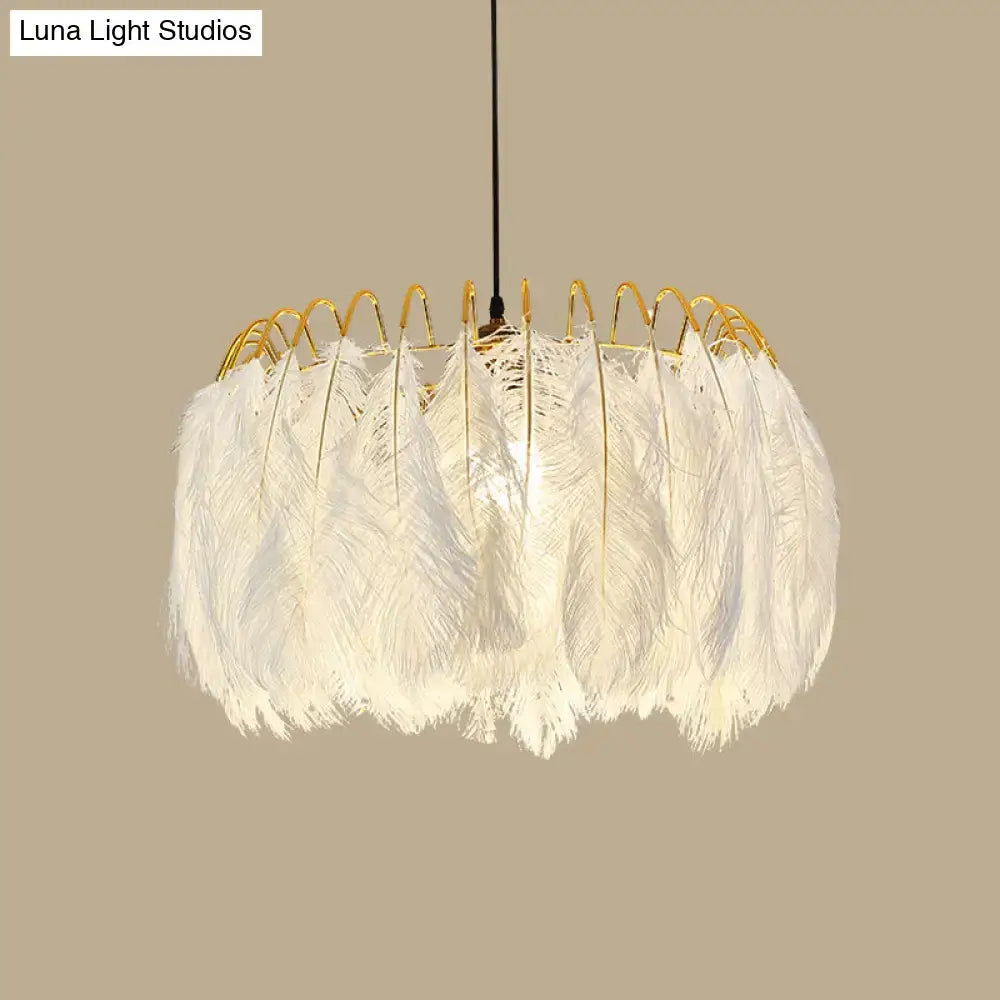 Modern white feather chandelier with gold-toned metal frame designed as a living room pendant light fixture