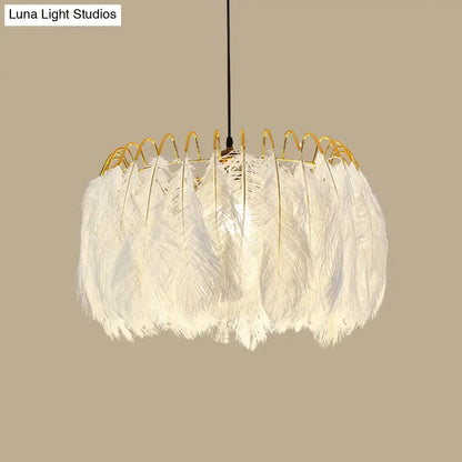 Modern white feather chandelier with gold-toned metal frame designed as a living room pendant light fixture
