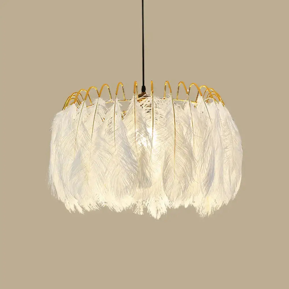A modern white feather chandelier with a gold wire frame designed as a living room pendant light