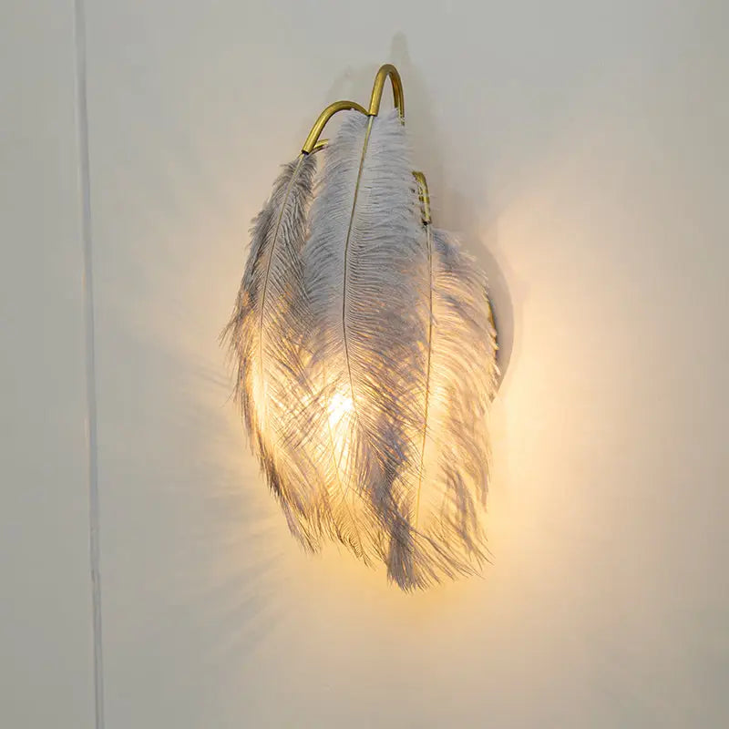 Modern white feather metal wall sconce with gold-toned frame for elegant bedroom lighting and modern metal decor