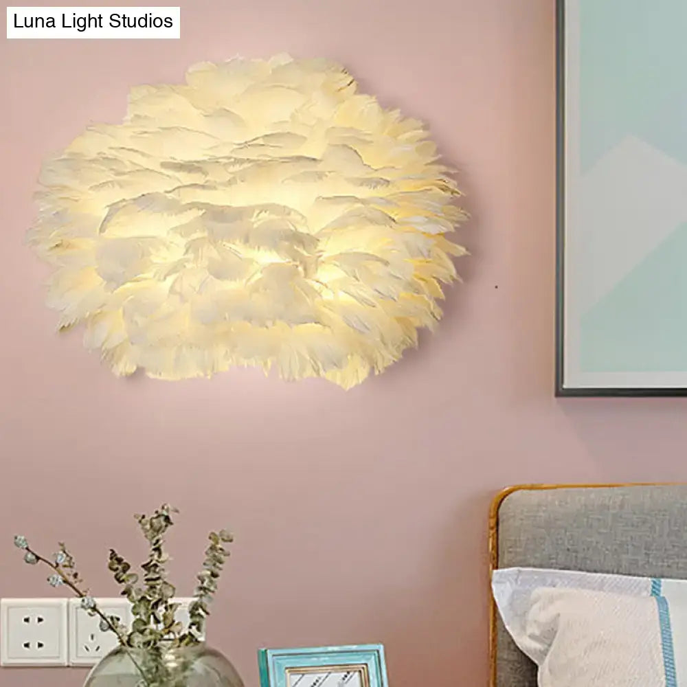 A modern cream-colored feather wall lamp with a fluffy layered design for stylish home decoration bedroom use
