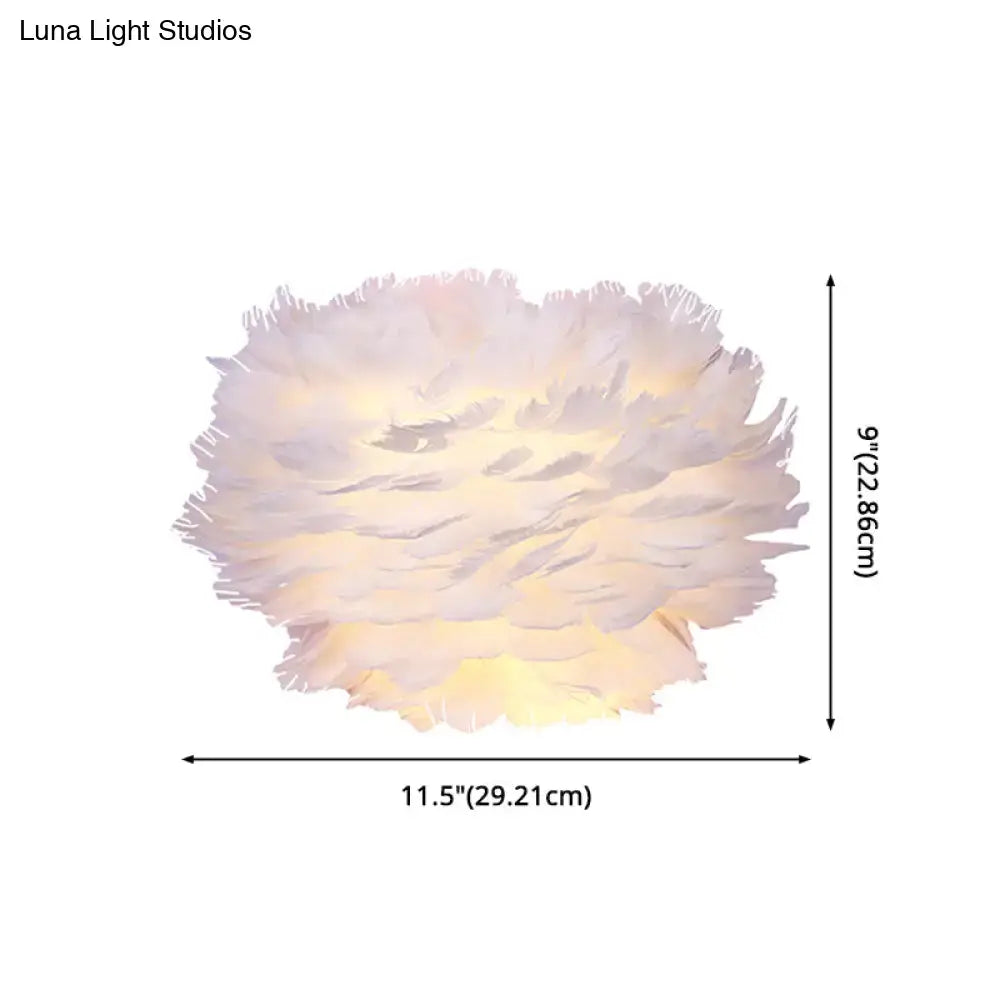 A modern white feather wall lamp with a warm glow serving as stylish home decoration for bedroom walls
