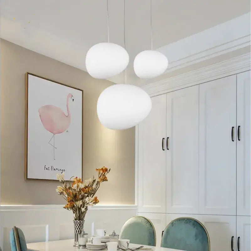 Three white frosted glass ball led pendant lights hang from the ceiling in a modern dining room decorbites glass ball set