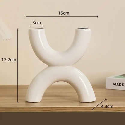 Modern white geometric ceramic candle holder with abstract u-shaped design and two curved openings for decorbites decor