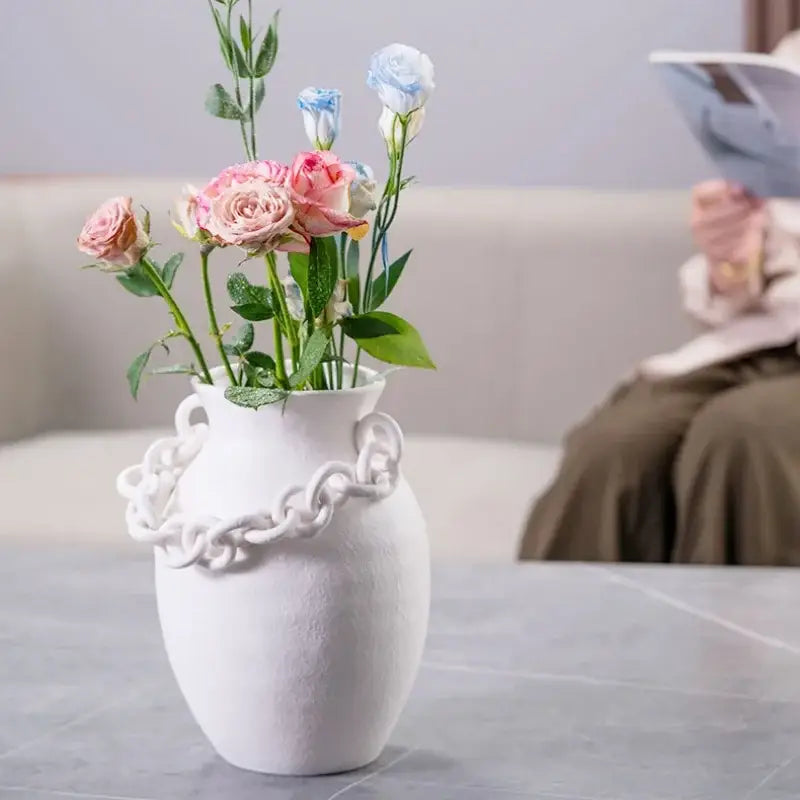 Modern white geometric chain porcelain vase with sculpted chain design holding pink and blue roses for living room decorbites geometric chain decor