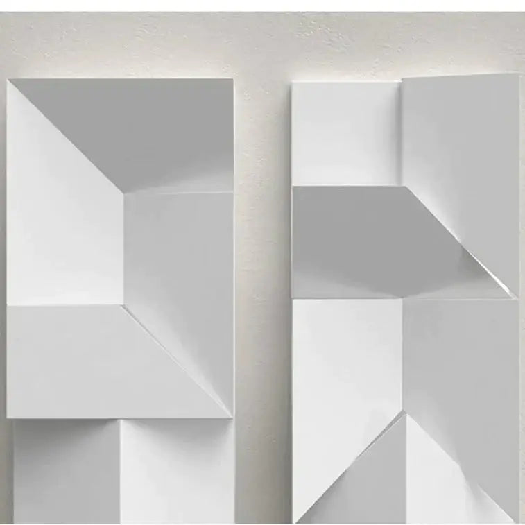 Modern white geometric wall lamp with angular three-dimensional facets illuminated for living room art