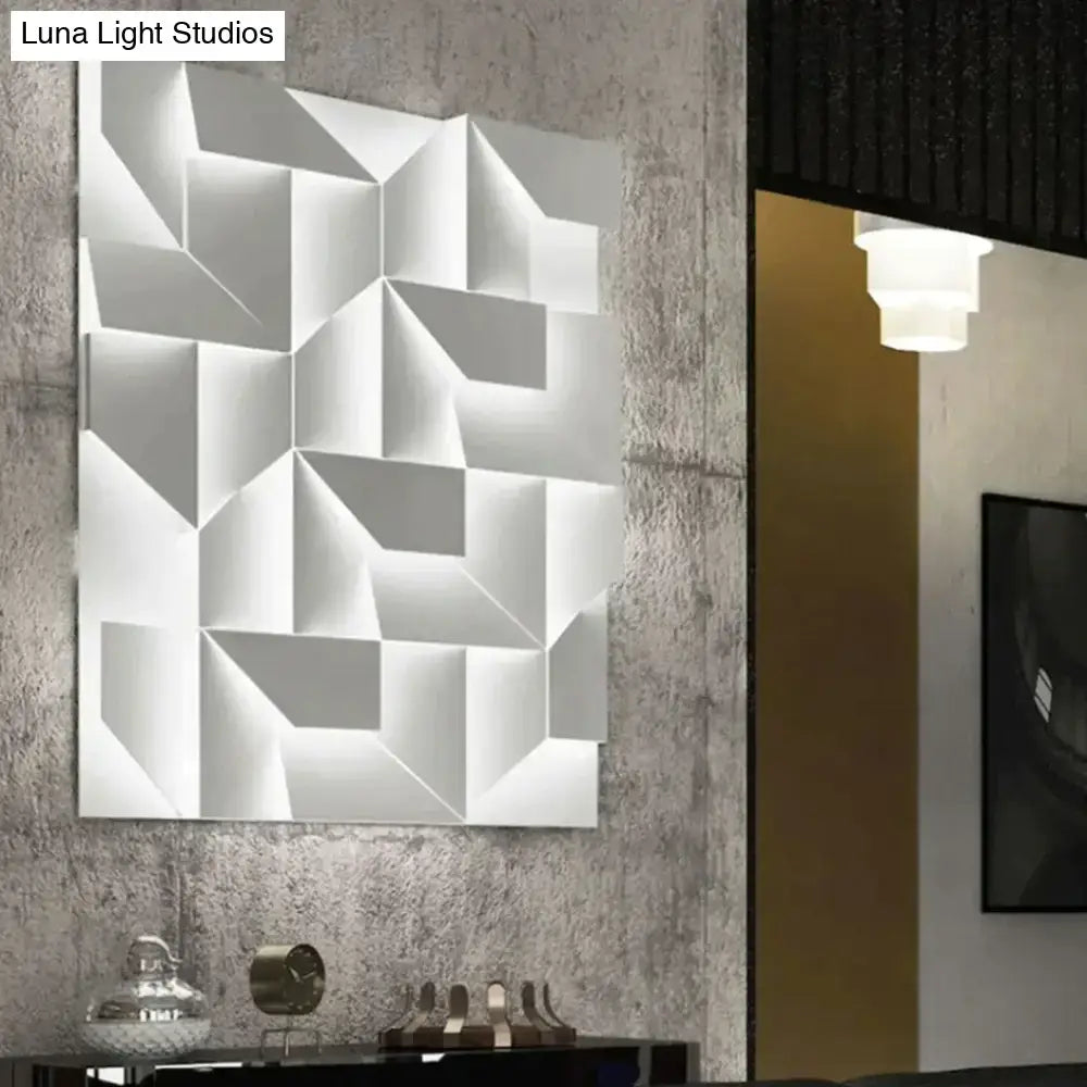 Modern white geometric wall lamp featuring a three dimensional design illuminated for living room decor