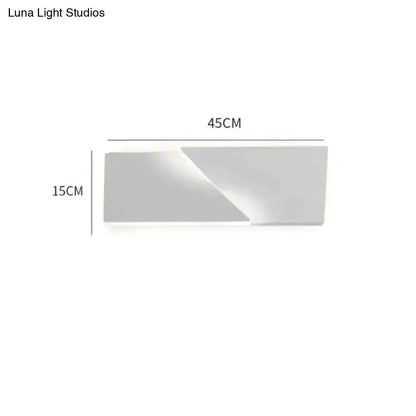 Modern minimalist rectangular wall sconce with a matte white finish and geometric design for living room illumination
