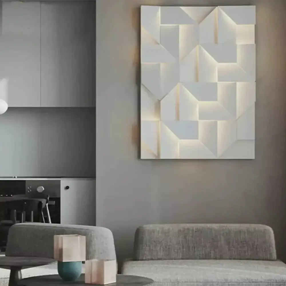 Modern white geometric wall lamp with illuminated recessed panels creating a three-dimensional angular pattern