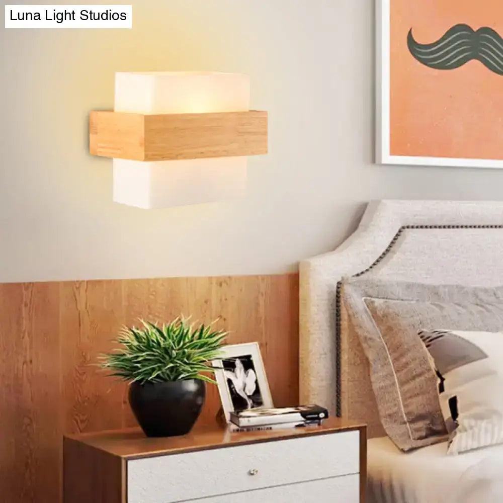 Modern wall light with minimalist stacked wood and frosted white glass emitting warm glow for bedroom sconce lighting