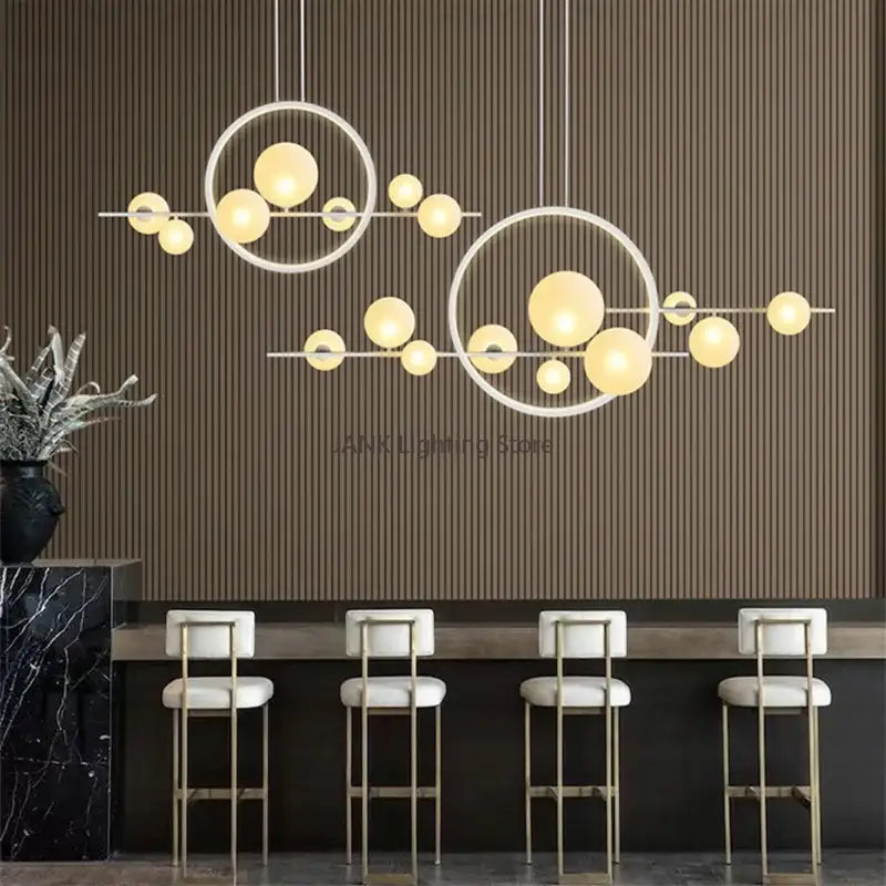 Modern white glass strip bubble chandelier with warm yellow globe bulbs suspended above kitchen bar decorbites glass strip