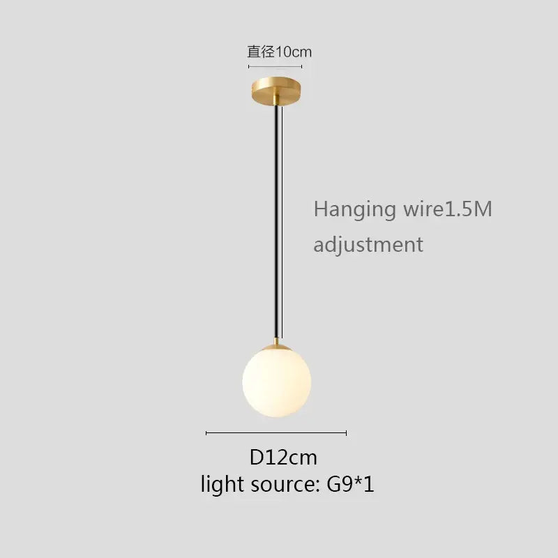 Modern pendant light with gold finish, matte white globe shade, and black hanging wire for kitchen or dining room