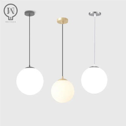 Three modern pendant lights with white globe shades and minimalist black gold and silver metal fixtures for kitchen dining room