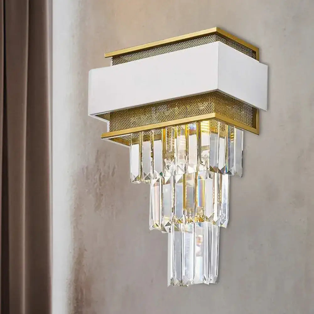 Modern white and gold wall sconce with mesh accents and hanging crystal prisms for a stylish wall lamp