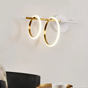 Modern white and gold ring light fixture with two glowing circular rings as a sleek wall light for living rooms