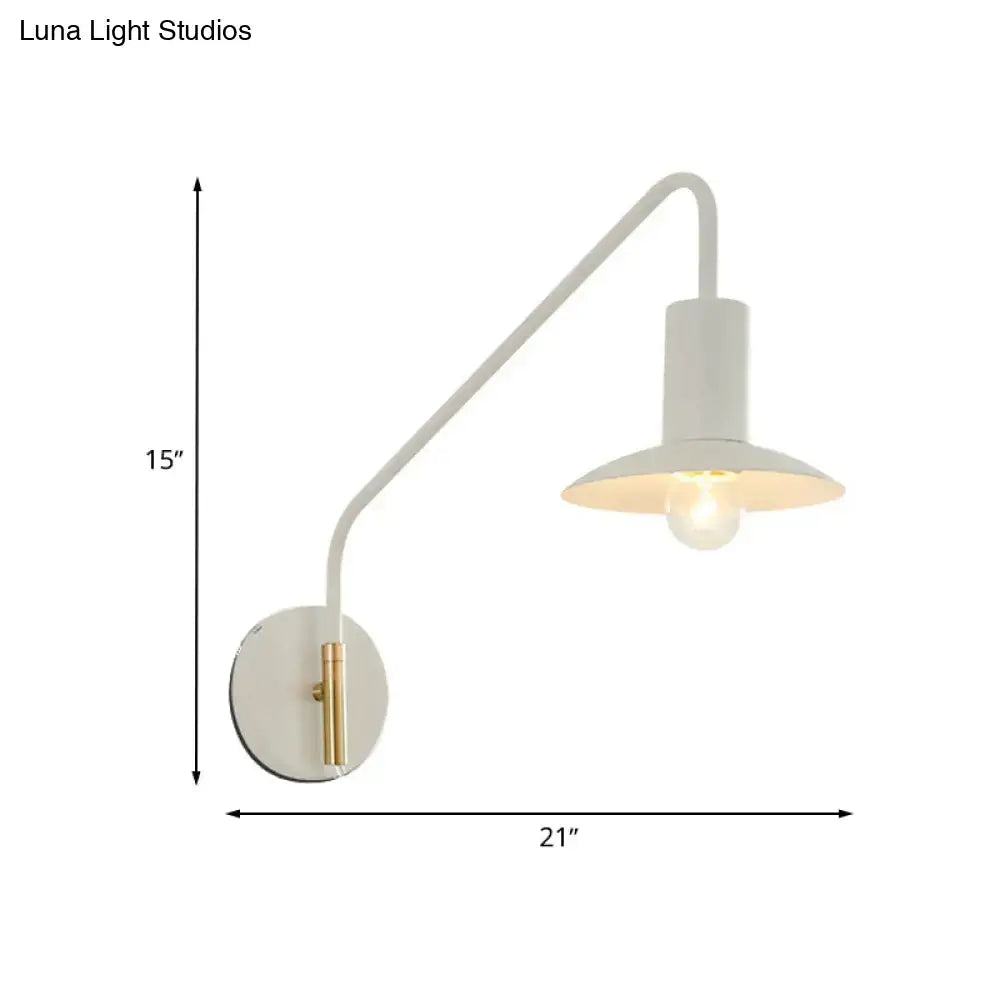 Modern white and gold bedroom wall lighting with wide flare curved arm and cylindrical shade over exposed bulb