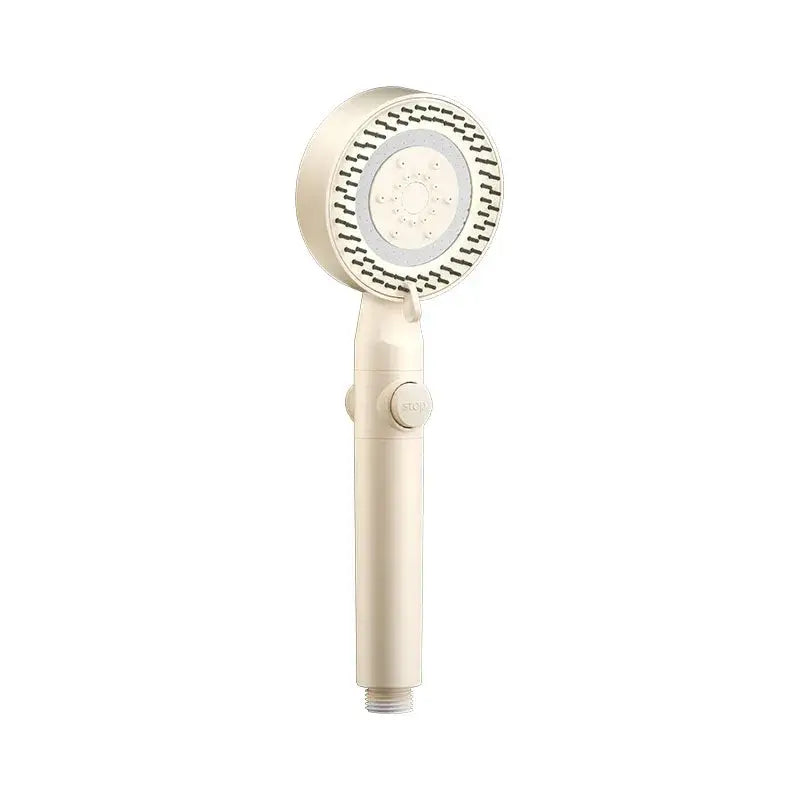 Cream-colored handheld showerhead with circular nozzles and control button in modern white shower set for high pressure mist