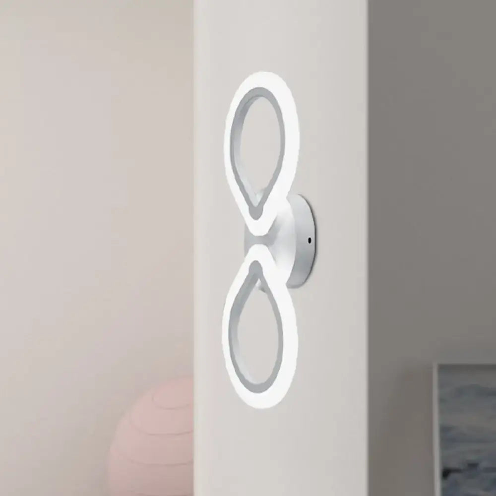 Modern white led wall sconce with two interlocking ring light fixtures featuring a simple design and optimal fixture height