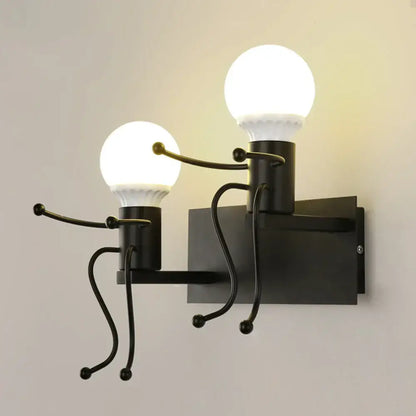 Modern white iron man cartoon wall sconce with black metal stick-figure arms holding spherical light bulbs for bedroom