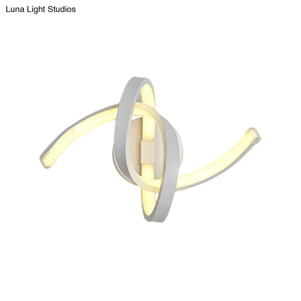 Modern white knotted linear wall sconce with intertwined gray metallic rings and warm yellow LED light for bedroom