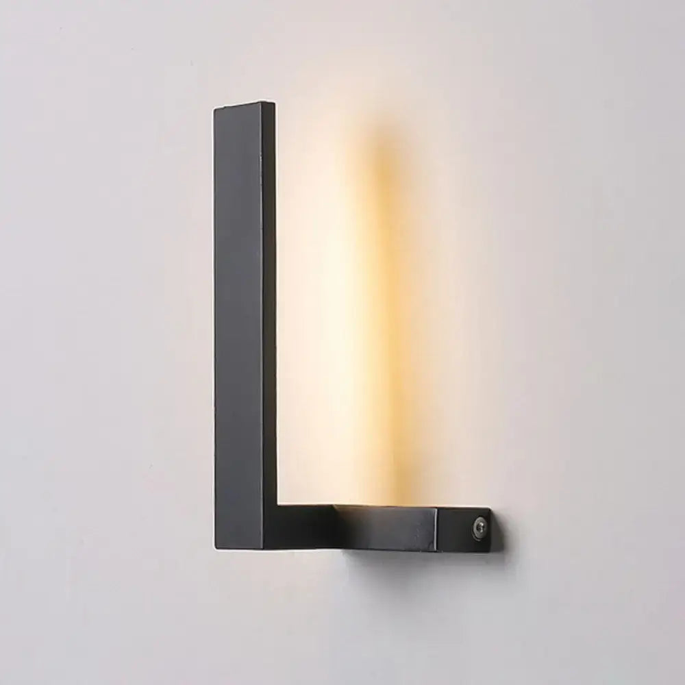 Black l-shaped led wall sconce with sleek minimalist design emitting warm light for modern living room lighting
