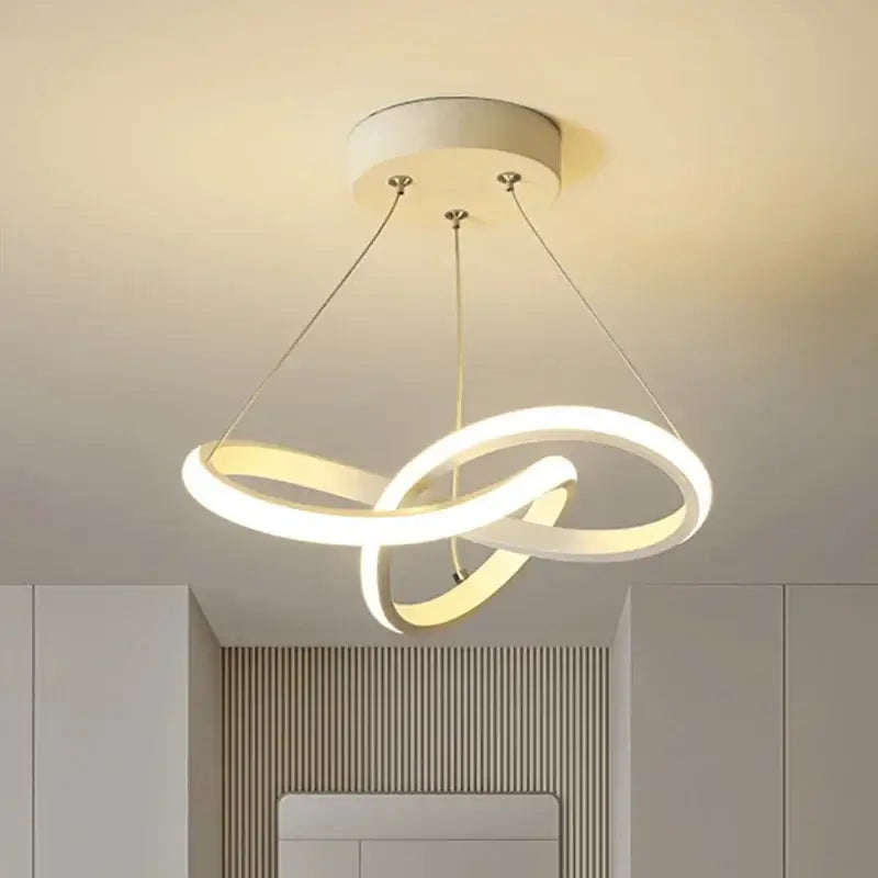 Modern white led pendant light with two interlocking rings suspended by metallic cords helps create elegant dining room light source