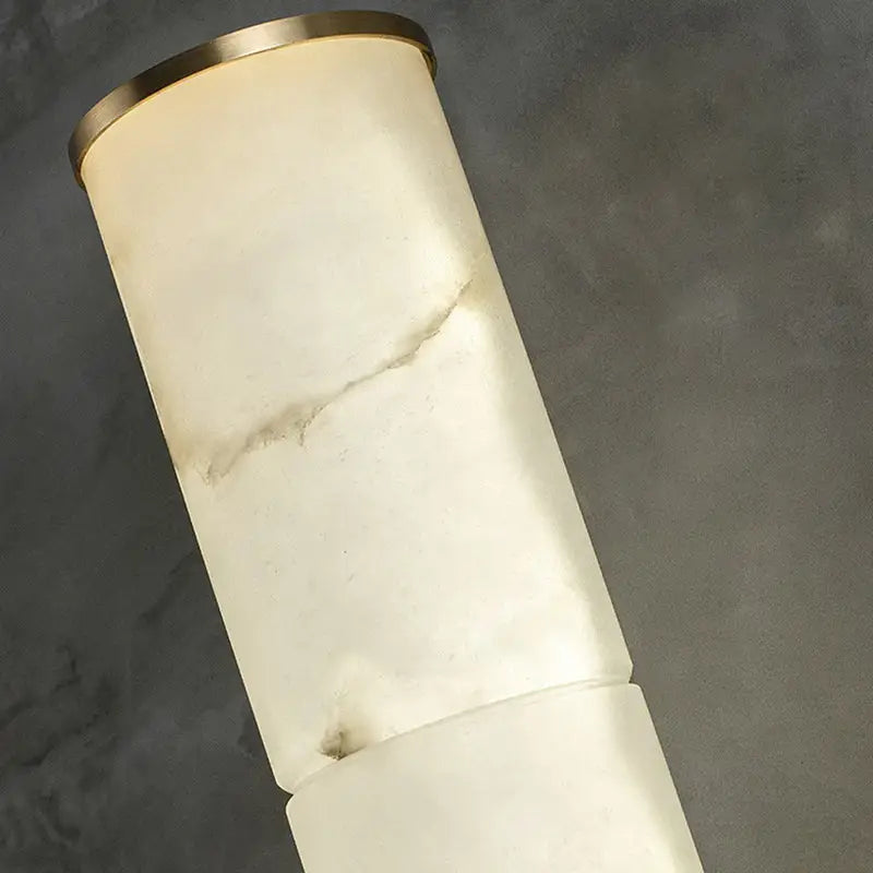 Modern white marble and brass wall lamp with cylindrical fixture and polished brass rim for living room lighting