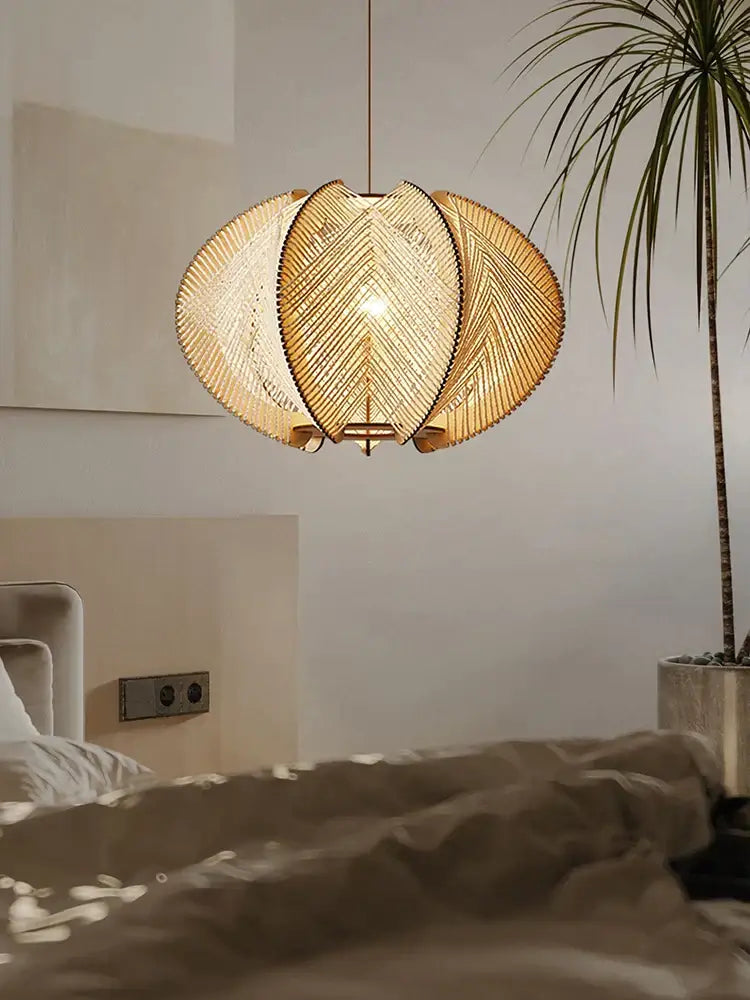 Modern white marble dining table with wood base paired with warm-toned handmade rattan pendant light decorbites design