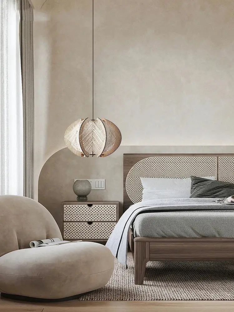 A woven spherical handmade rattan pendant light with natural wood finish hanging above a modern white marble dining table