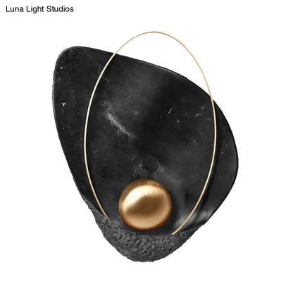Modern white marble and gold teardrop wall lamp with black marble sculpture, gold wire, and central golden pearl, 18 inch fixture height